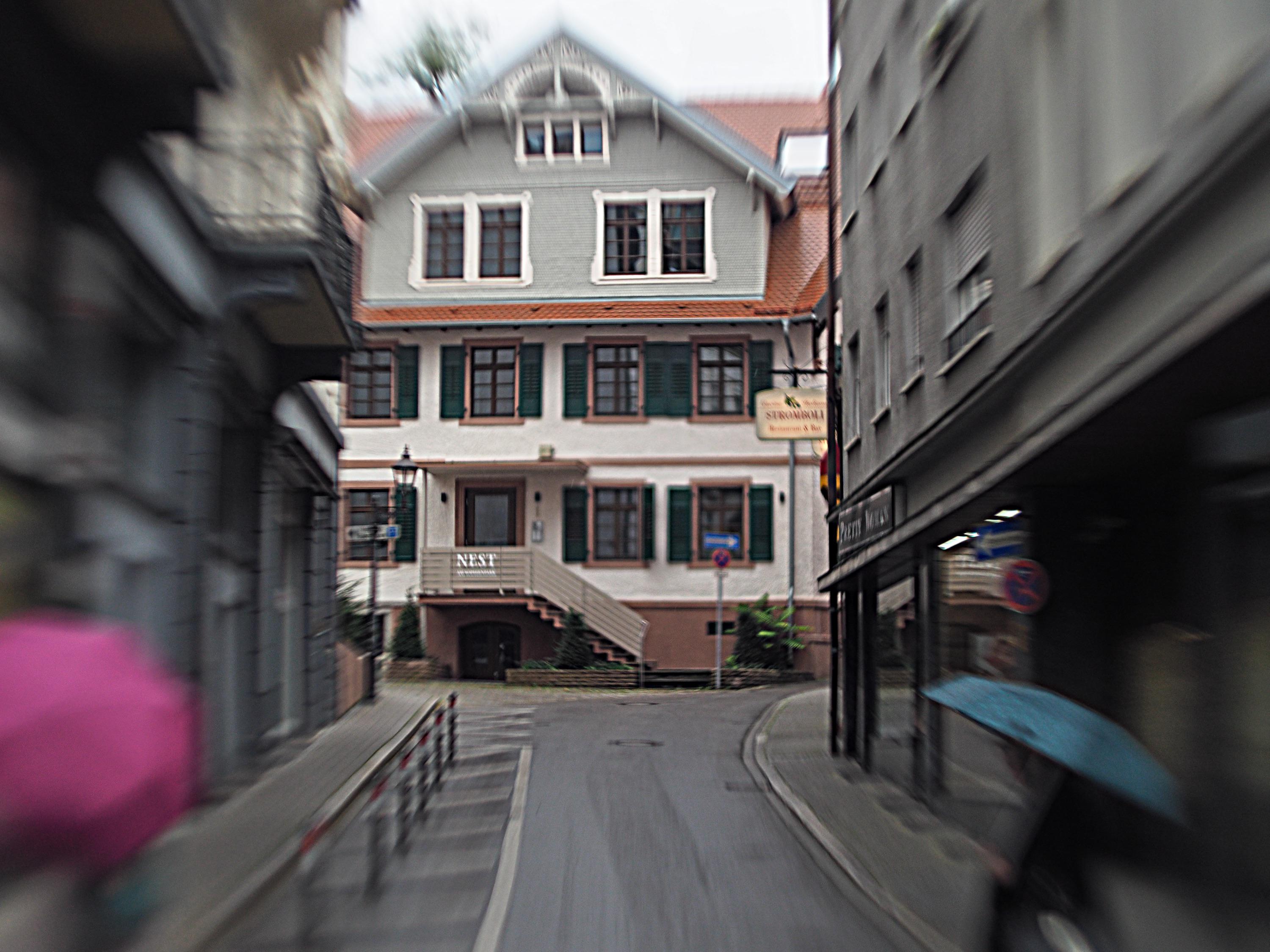 Durchblick zum Nest.Häuserschlucht mit Durchblick, Regenschirme links und rechts